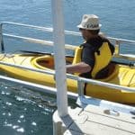 Bright yellow kayak with paddle, perfect for water sports enthusiasts.