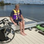 Wheelchair accessible boat dock with adaptive seating and watercraft at Camp & Cruise.