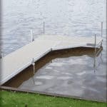 Metal dock platform with safety rails by the water, ideal for sports activities and waterfront recreation.