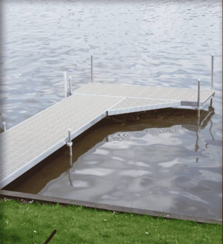 Metal dock platform with safety rails by the water, ideal for sports activities and waterfront recreation.