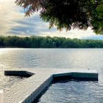 Beautiful lakeside dock surrounded by trees with a tranquil water view, ideal for outdoor recreation and leisure.