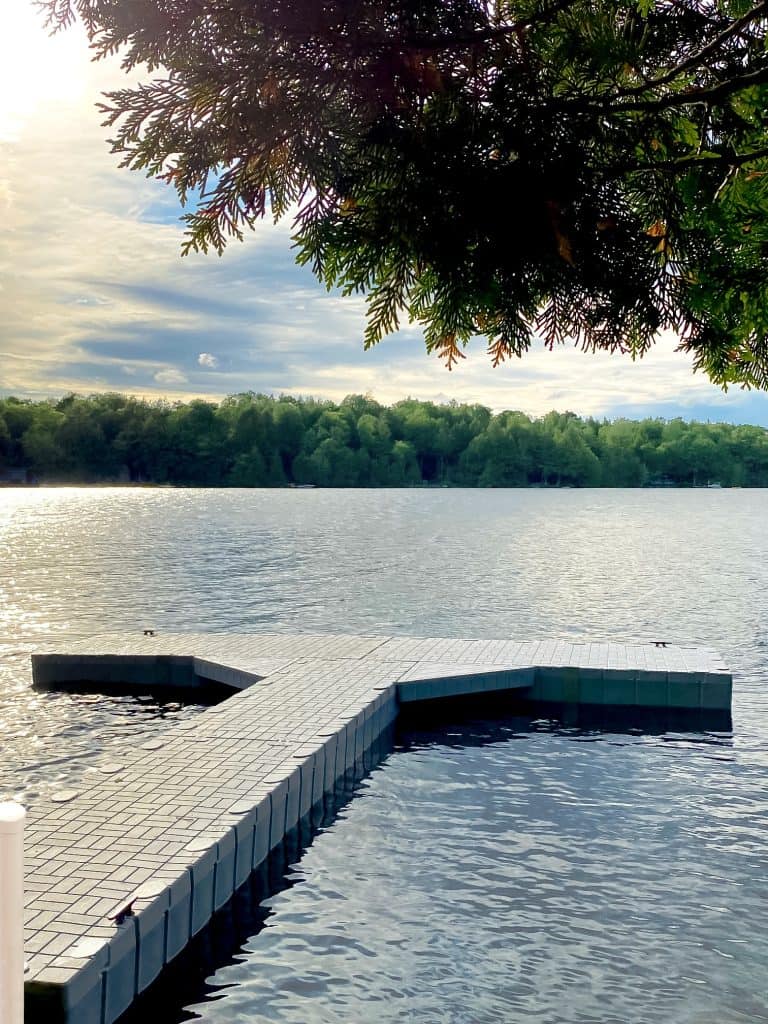 Beautiful lakeside dock surrounded by trees with a tranquil water view, ideal for outdoor recreation and leisure.