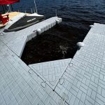 Floating dock with jet ski storage area on a serene lake. Durable, modular design perfect for waterfront recreation.