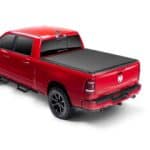 Red Dodge Ram truck at Camp & Cruise showroom displaying vehicles and sports gear.