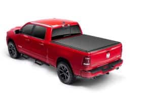 Red Dodge Ram truck at Camp & Cruise showroom displaying vehicles and sports gear.