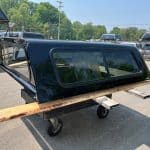 Black truck bed with window and wooden support for GMC 1500.