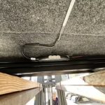 Underground electrical cable running along the ceiling of a vehicle bed area.