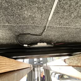 Underground electrical cable running along the ceiling of a vehicle bed area.