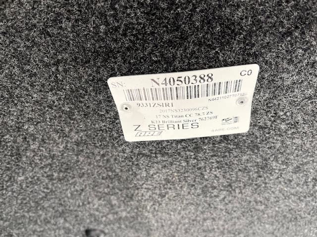 Close-up of Nissan Titan bed accessory label with serial and part info.