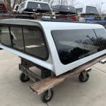 Silver truck cap with tinted windows for Nissan Titan pickup truck.