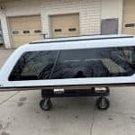 White truck cap with tinted windows for Ford F150 on a dolly.