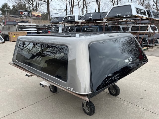 Gray truck cap for GMC 1500 with tinted windows and aerodynamic design.