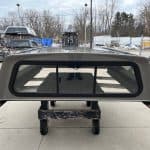 Gray GMC 1500 truck cap with rear window and side panels.
