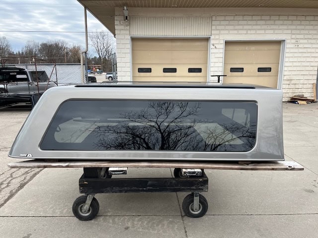 Gray GMC 1500 truck cap panel with tinted windows for demo.
