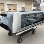 Gray GMC 1500 truck cap with tinted windows and aerodynamic design.
