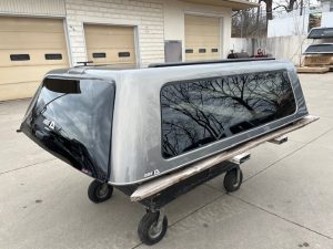 Gray GMC 1500 truck cap with tinted windows and aerodynamic design.