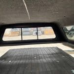GMC 1500 truck bed cap with window and cargo area.