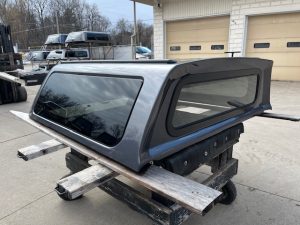 Gray truck cap with tinted windows for Ford Ranger, outdoor setting.