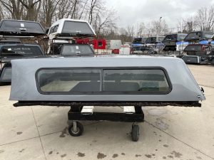 Gray 8-foot Chevy 1500 truck cap with tinted window.