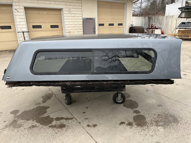 Gray 8-foot Chevy 1500 truck cap with window for pickup truck.