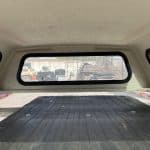 Interior view of a Ford Ranger 60" cap with rear window and cargo area.