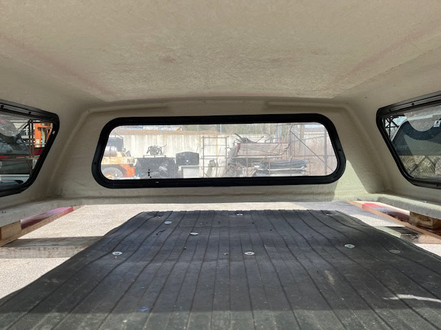 Interior view of a Ford Ranger 60" cap with rear window and cargo area.