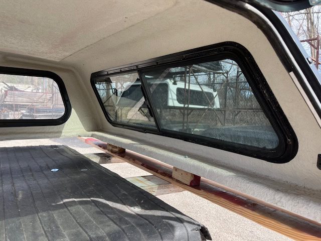 Red Ford Ranger 60-inch truck cap with tinted windows inside the vehicle.