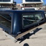 Black truck bed cap with tinted windows for Chevy 1500 pickup truck.