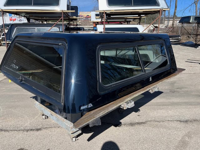 Black truck bed cap with tinted windows for Chevy 1500 pickup truck.