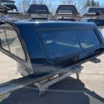 Black truck cap for Chevy 1500 with tinted windows and aerodynamic design.