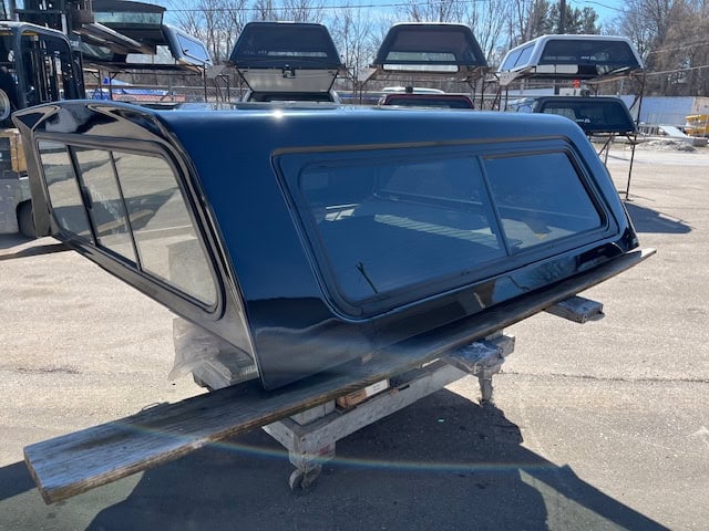 Black truck cap for Chevy 1500 with tinted windows and aerodynamic design.