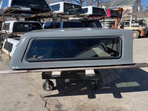 Gray truck bed cap with window for RAM 1500 in ceramic gray color.