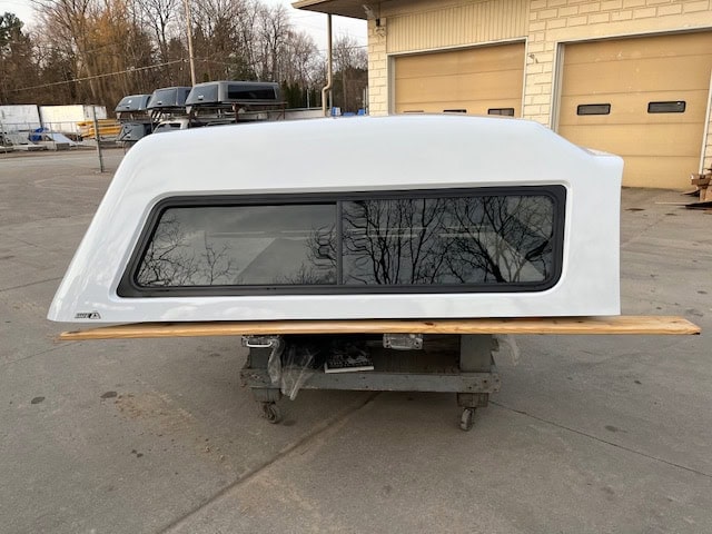 Summit white truck cap for Chevy HD 14-19 with window and wooden base.