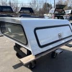 White truck bed cap with tinted windows and side storage door.