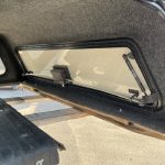 Truck bed cap with tinted window and gas strut for easy opening.