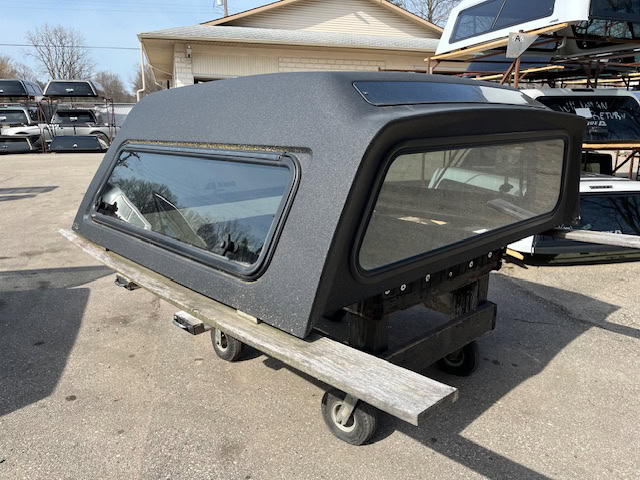 Gray truck cap for GMC 1500 with tinted windows and durable construction.