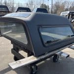 Gray truck cap with windows for GMC 1500 pickup truck.