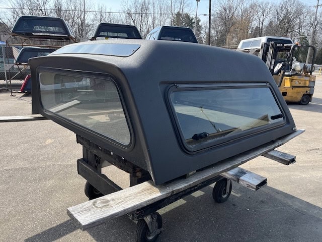 Gray truck cap with windows for GMC 1500 pickup truck.