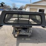 Gray truck bed cap with tinted rear window for RAM 1500.
