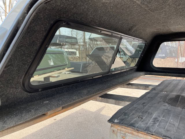 Truck bed cover with tinted window for RAM 1500 in ceramic gray.