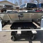 Heavy-duty truck bed storage with lift-up lid and wheels for mobility.