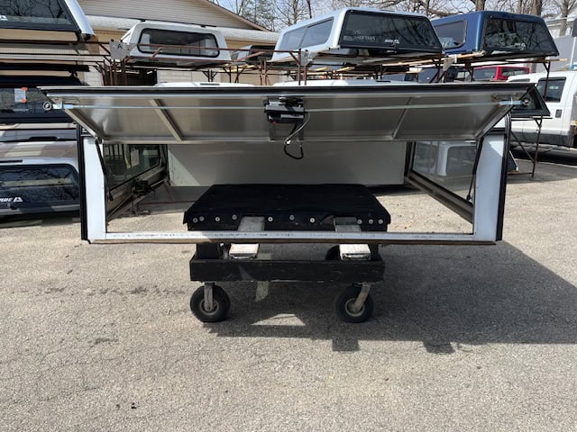 White utility bed for Ford SD with open side panels and storage compartments.