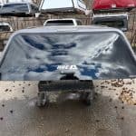 Rear truck cap window reflecting cloudy sky and surrounding environment.