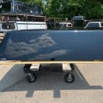 Black Chevy HD 82-inch truck bed on a cart in outdoor storage.