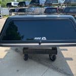 Black truck bed cover for Chevy HD 82" with tinted window and rear lock.