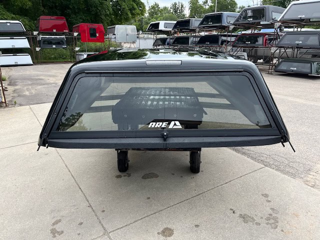 Black Chevy HD 98" truck cap with window and mounting hardware.