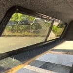 Side window of truck cap with tinted glass and black frame.