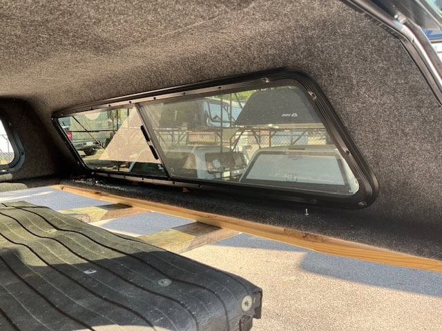 Truck bed window with tinted glass and black frame for Chevy 1500.