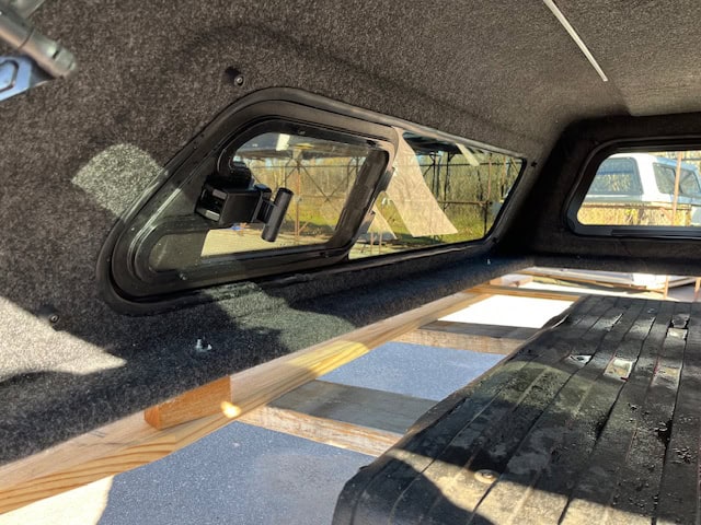 Lakeshore Blue GMC HD truck bed with interior view and window.