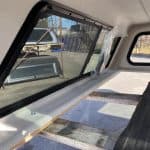 Side window of a truck with tinted glass and black frame.
